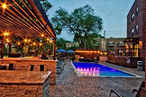 Kansas City apartment for rent - A pool area with a stone wall and a pergola.