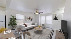 Gardner apartment for rent - A living room with a white couch, a coffee table, and a ceiling fan.