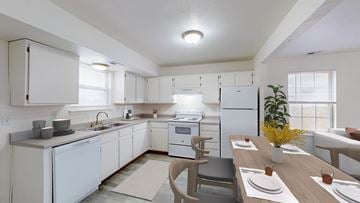 Gardner townhouse for rent - A modern kitchen with white appliances and a dining table set for two.