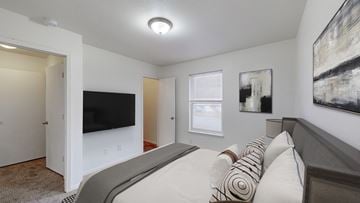 Gardner apartment for rent - A bedroom with a large bed and a flat screen TV.