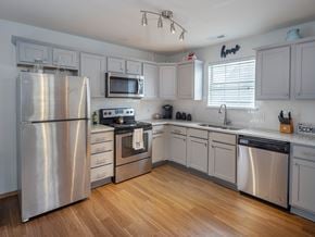Lawrence townhouse for rent - A kitchen with a stainless steel refrigerator, microwave, oven, and dishwasher.