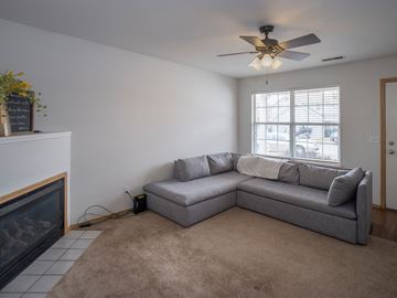 Lawrence townhouse for rent - A living room with a grey couch and a fireplace.