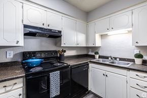 Grandview apartment for rent - a kitchen with black appliances and white cabinets