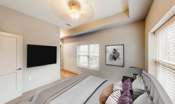 Overland Park apartment for rent - A bedroom with a large bed and a flat screen TV.