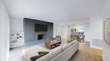 Kansas City apartment for rent - A modern living room with a grey couch and a fireplace.