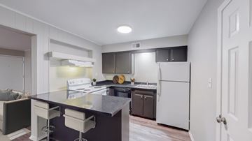 Kansas City apartment for rent - A kitchen with a white fridge and a black counter top.