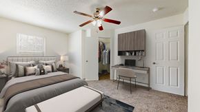 Olathe townhouse for rent - A bedroom with a bed, desk, and a ceiling fan.