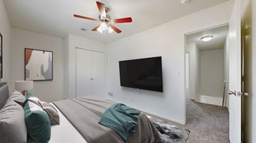 Olathe townhouse for rent - A living room with a grey couch and a black television.