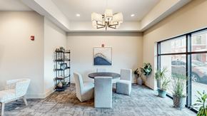 Overland Park apartment for rent - A room with a round table and chairs, a shelf, and a painting on the wall.