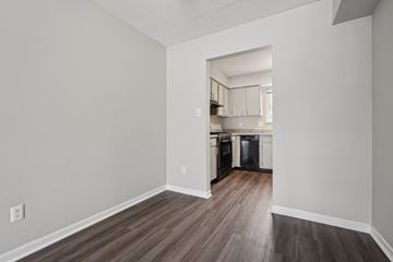 Bloomington apartment for rent - A kitchen with a refrigerator, oven, and cabinets is visible through an open doorway.