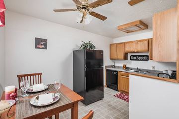 Bloomington apartment for rent - A kitchen with a black refrigerator and wooden cabinets.