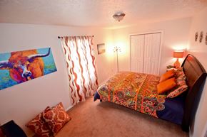 Bloomington apartment for rent - A bedroom with a bed, pillows, and a painting on the wall.