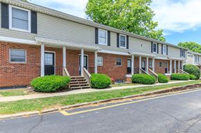 Bloomington apartment for rent - A row of houses with a tree in the background.