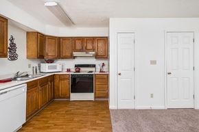 Bloomington apartment for rent - A kitchen with wooden cabinets and white appliances.
