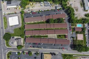 Bloomington apartment for rent - An aerial view of a parking lot with a building and a pool.