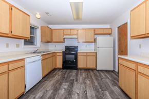 Bloomington apartment for rent - A kitchen with wooden cabinets and a black oven.