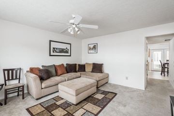 Bloomington apartment for rent - A living room with a beige couch and a rug.
