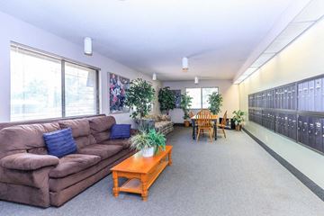 Lafayette apartment for rent - A living room with a brown couch, a coffee table, and a dining table with chairs.