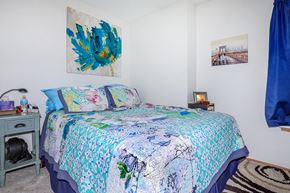 Lafayette apartment for rent - A bedroom with a bed covered in a blue and white floral comforter.