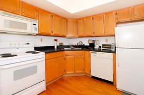 Lafayette apartment for rent - A kitchen with wooden cabinets and white appliances.