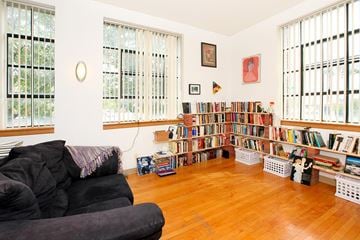 Lafayette apartment for rent - A living room with a black couch and a bookshelf filled with books.