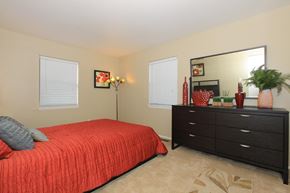 West Lafayette apartment for rent - A bedroom with a red bedspread and a black dresser.