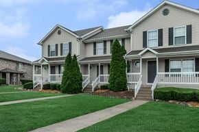 Dekalb apartment for rent - A row of houses with green lawns in front.