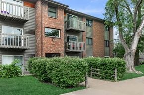 Dekalb apartment for rent - Apartment building with balconies and a tree in front.
