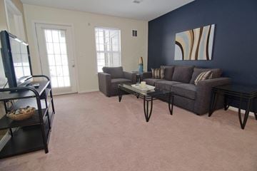 Lansing townhouse for rent - Living room with a grey couch and a painting on the wall.