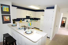 Lansing townhouse for rent - A kitchen with white cabinets and a black stool.