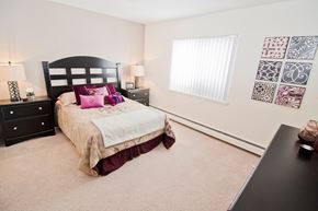 Lansing townhouse for rent - A bedroom with a large bed and a black dresser.