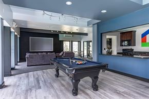 East Lansing townhouse for rent - A pool table is in the middle of a room with a couch and a television.