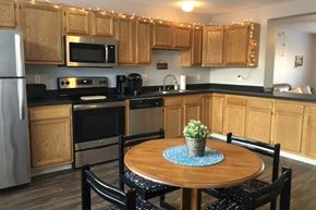 Bloomington apartment for rent - A kitchen with wooden cabinets and a table with a plant on it.