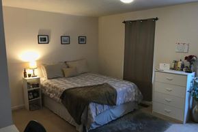 Bloomington apartment for rent - A bedroom with a bed, nightstand, and a chair.