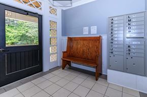 Bloomington apartment for rent - A wooden bench is placed in front of a mailbox.