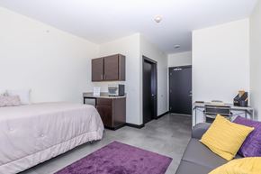 Bloomington apartment for rent - A bedroom with a bed, a couch, and a cabinet.