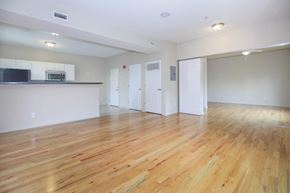 Bloomington apartment for rent - A spacious room with wooden flooring and white walls.