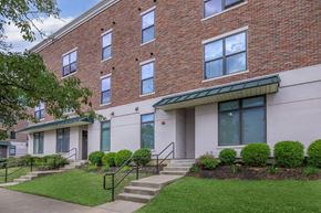 Bloomington apartment for rent - A brick building with a green roof and a white door.