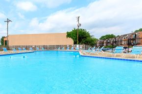 Lafayette apartment for rent - A large swimming pool with blue water and lounge chairs.