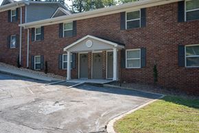 Atlanta apartment for rent - the front entrance of a brick building with a driveway