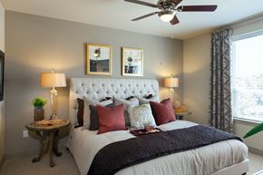 Houston apartment for rent - A bedroom with a large bed and a ceiling fan.