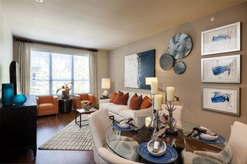 Houston apartment for rent - A modern living room with a glass table and a sofa.