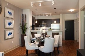 Houston apartment for rent - A modern dining room with a glass table and white chairs.