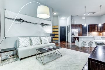 Houston apartment for rent - A modern living room with a white sofa and a glass coffee table.