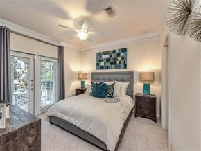 Houston apartment for rent - a bedroom with a bed and a ceiling fan