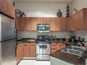 Houston apartment for rent - a kitchen with stainless steel appliances and wooden cabinets