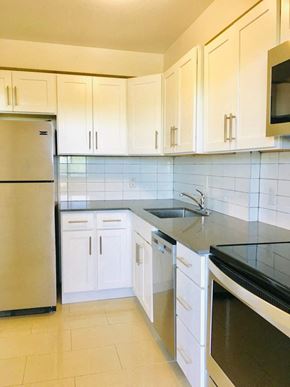 Toronto apartment for rent - a kitchen with white cabinets and a sink and a refrigerator