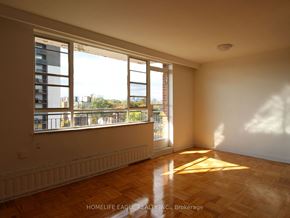 Toronto apartment for rent - an empty living room with large windows and wooden floors