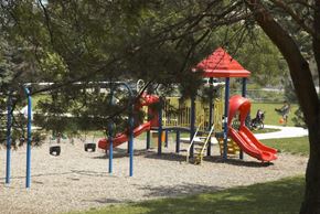 Toronto apartment for rent - a playground with a swing set and slides in a park