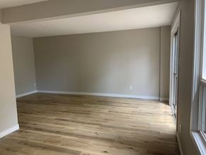 Oakville apartment for rent - an empty living room with wooden floors and grey walls